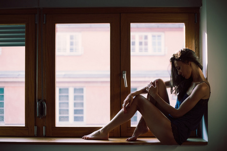 孤独的女孩坐在窗边