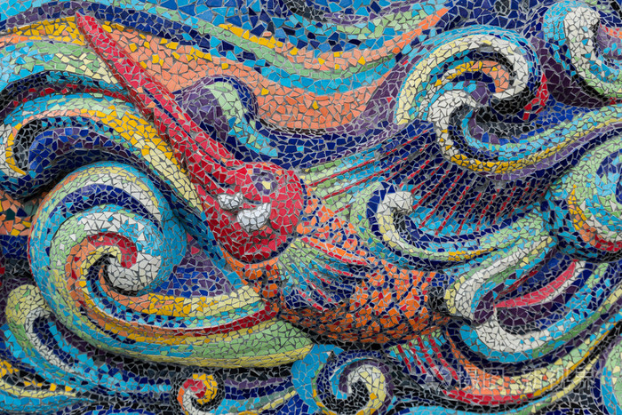 色彩斑斓的玻璃马赛克艺术形状鱼和抽象墙背景