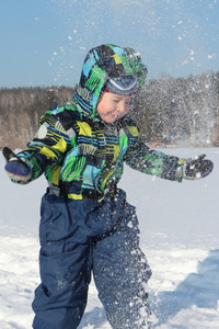 里色外套带兜帽的小男孩抛雪