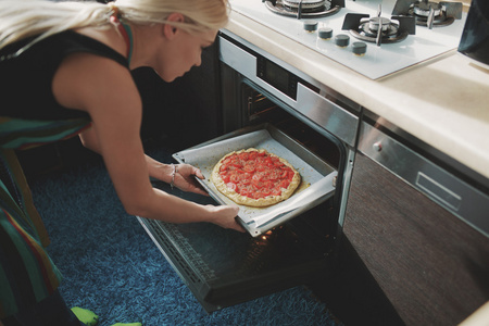 烹饪比萨在厨房的女人