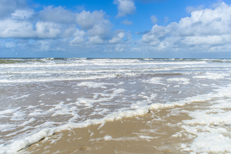 风和浪创建泡沫在沙滩上