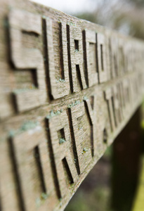 手工雕刻的旧木凳上刻着青苔的字母