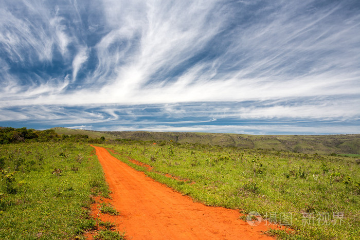 农村橙色土路与蓝蓝的天空和遥远的地平线