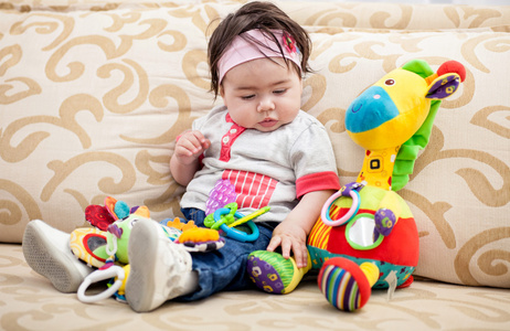 可爱的小宝宝和色彩鲜艳的玩具在家里玩