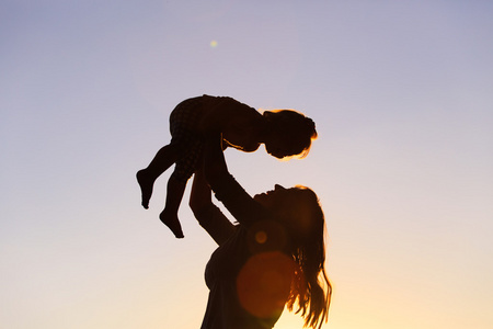 母亲和小女儿玩在日落时分