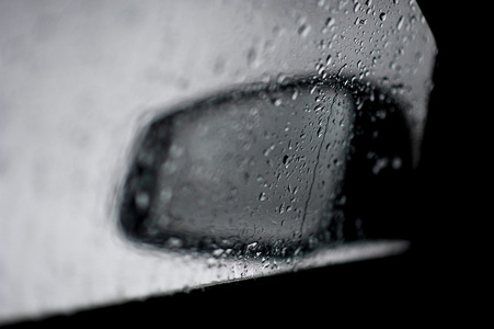 汽车后视镜。用雨滴查看玻璃