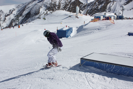 年轻的滑雪者女人在一个盒子上滑行