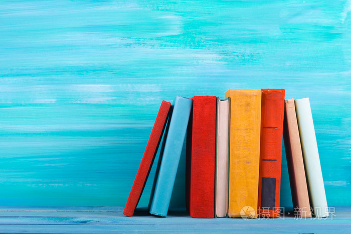 堆栈的五彩斑斓的图书,又脏又臭的蓝色背景,免费副本空间