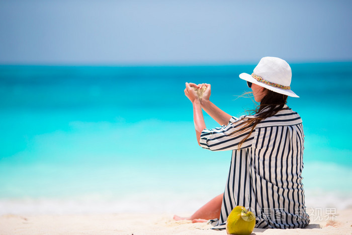年轻漂亮的女人在海滩度假