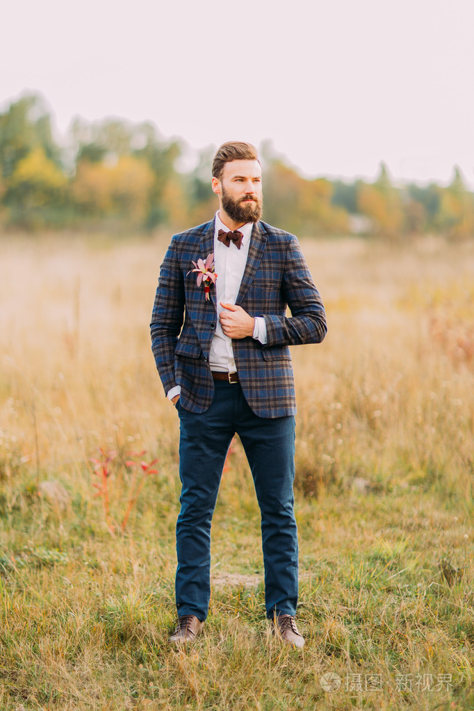 留着胡子在秋天的原野上摆姿势帅时髦新郎