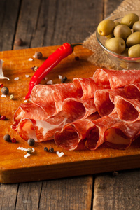 意大利香肠用橄榄和香料木制背景
