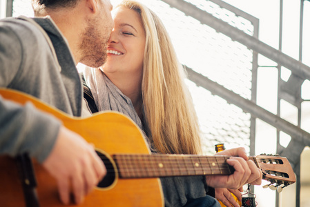 美丽的年轻夫妇，弹吉他和亲吻