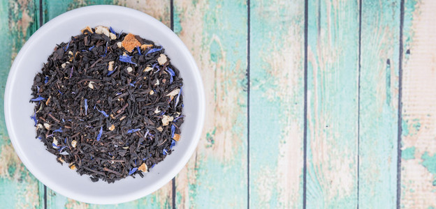 白色碗中的紫灰色黑茶，在木制背景上