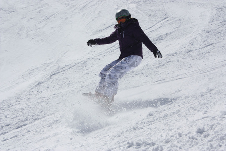 年轻的滑雪者女人大幅滑下坡和制动