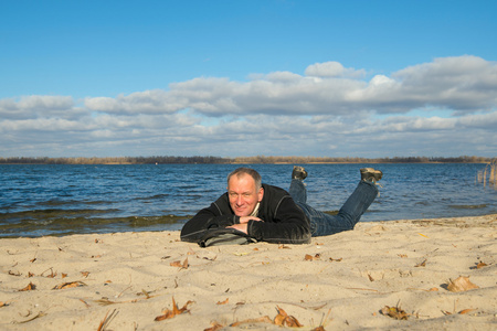 开心的样子徒步旅行者人在海岸上放松,躺在沙滩上,微笑的样子照片