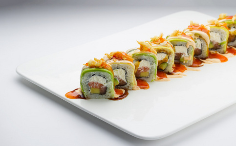 黑色背景挞三文鱼和奶酪意面健康的夹心奶酪和三文鱼寿司卷内有沙拉