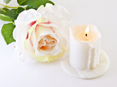 玫瑰和一支燃烧的蜡烛图片