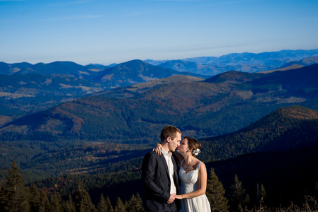 新娘和新郎轻轻亲吻。 令人惊叹的山景