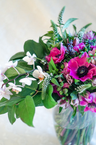 浪漫束美丽的粉红海葵和兰花花在白色背景上的花瓶