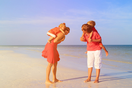 年轻的家庭，两个孩子在海滩散步