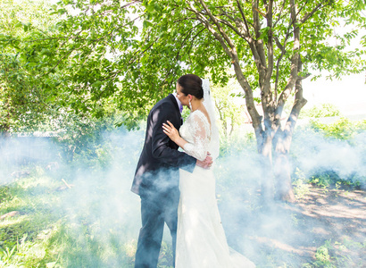 婚礼情侣接吻的背景下朦胧的花园