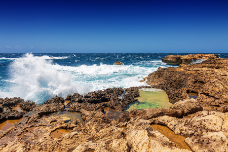 汹涌的波浪打破对岩石岸杜埃湾在马耳他戈佐岛