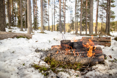 在冬季远足釜挂在火上烹饪