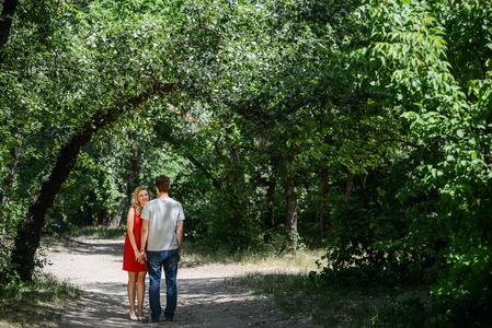 年轻漂亮的夫妻在绿色的夏天公园