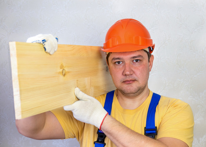 安全帽用木板的雄性建筑工人