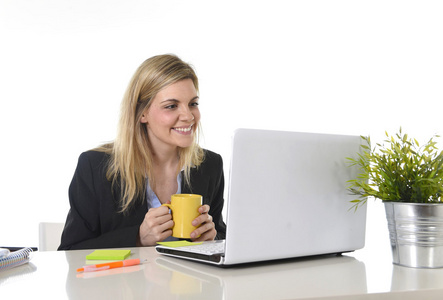 在现代办公台膝上型计算机上工作的快乐高加索金发业务女士