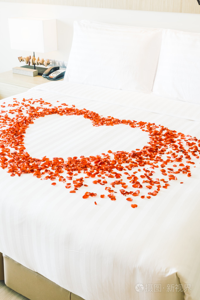 在床上和玫瑰花瓣上的白色枕头