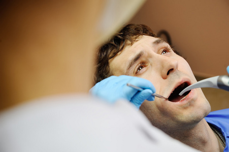 在牙科诊所的年轻小伙子。牙医的恐惧