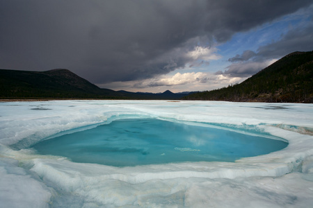 在融化的冰和云在天空中的小湖