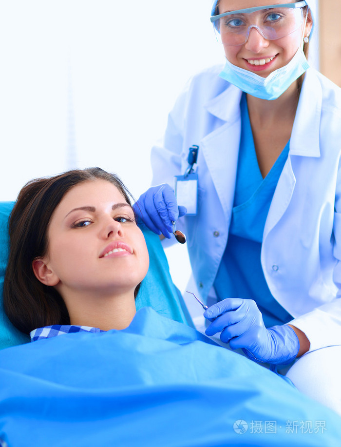 女牙医在她病人牙齿工作