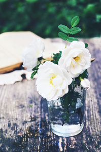 夏天的白色的野玫瑰，在花园里的餐桌上的花束