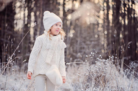 可爱的快乐女孩肖像在冬天的雪林里散步