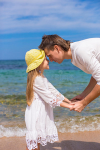 可爱的小女孩和快乐的爸爸在海滩上