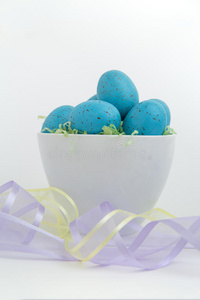 蓝色斑点鸡蛋在复活节草与粉彩带