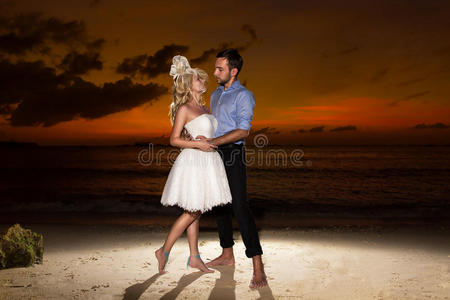 新娘和新郎在热带海滩上，背景是夕阳