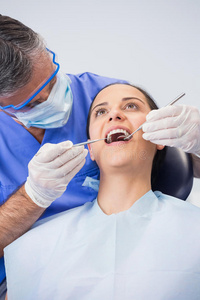 牙医用角镜和镰刀探针检查病人