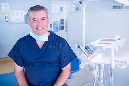 牙医对着椅子旁边的摄像机微笑