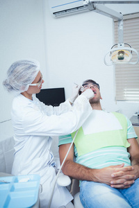 女牙医检查男人的牙齿
