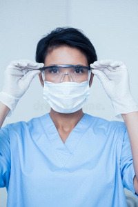 女性牙医戴着外科口罩和安全眼镜