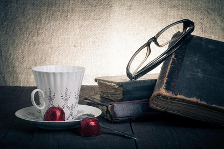 一杯咖啡，舒科拉德，眼镜和一叠旧书在O上