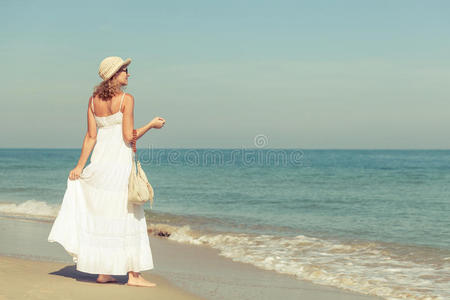 一个穿着白色裙子的女人在海边