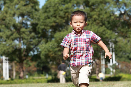 在草地上奔跑的日本男孩