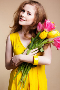 美丽的女孩带着五颜六色的郁金香