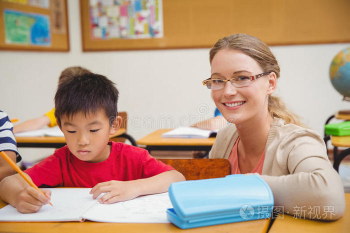 漂亮的老师在教室里帮助学生