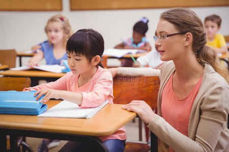 漂亮的老师在教室里帮助学生