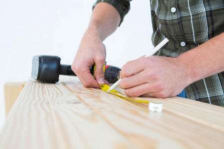 木匠用卷尺在木板上做标记